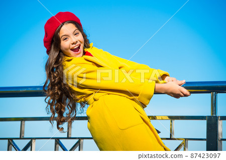 Kid little girl yellow coat red beret enjoy fall stand railing  87423097