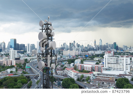 Telecommunication tower with 5G cellular network antenna on city background 87423796