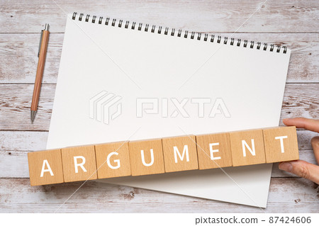 Image of discussion | Building blocks, notebooks, pens, human hands with "ARGUMENT" written on them 87424606