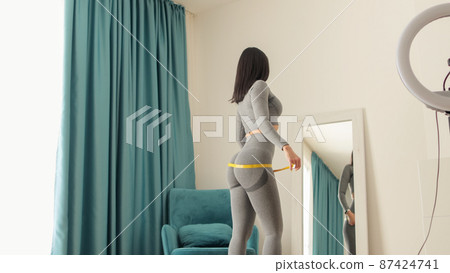 happy Woman Measuring body With Tape after weight loss fitness workout happy Woman Measuring body With Tape after weight loss fitness workout 87424741