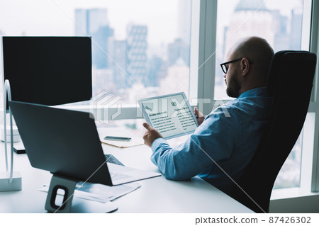 Male executive using tablet in modern office Male executive using tablet in modern office 87426302