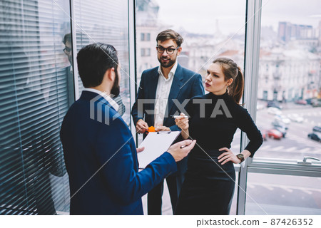 Group of colleagues discussing business plan in office 87426352