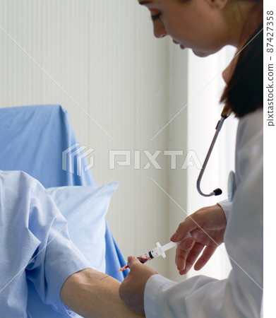 Young caucasian doctor collects blood sample from patient. Coronavirus disease 2019 testing process in a hospital. Young caucasian doctor collects blood sample from patient. Coronavirus disease 2019 testing process in a hospital. 87427358