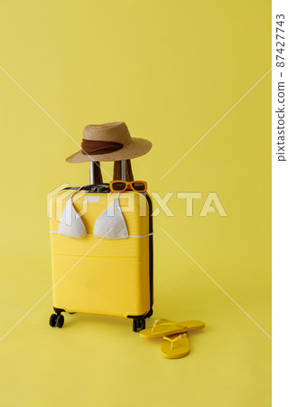 Travel bag, straw hat, sunglasses, flip flops and bra in studio 87427743