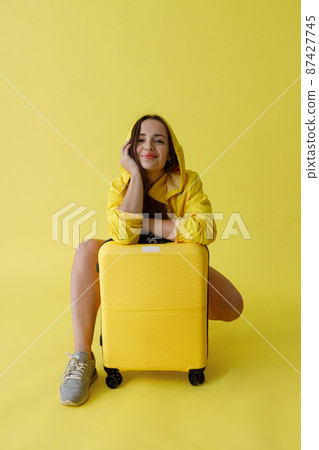 Charming woman with travel bag posing in studio Charming woman with travel bag posing in studio 87427745