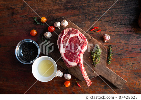 Sliced grilled thai steak served on white plate with grilled sliced lemon, tomatoes, garlic 87428625