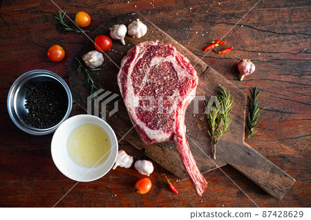 Sliced grilled thai steak served on white plate with grilled sliced lemon, tomatoes, garlic Sliced grilled thai steak served on white plate with grilled sliced lemon, tomatoes, garlic 87428629