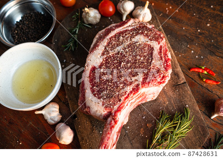 Sliced grilled thai steak served on white plate with grilled sliced lemon, tomatoes, garlic 87428631