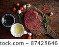 Sliced grilled thai steak served on white plate with grilled sliced lemon, tomatoes, garlic 87428646