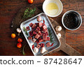 Sliced grilled thai steak served on white plate with grilled sliced lemon, tomatoes, garlic 87428647