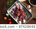 Sliced grilled thai steak served on white plate with grilled sliced lemon, tomatoes, garlic 87428648
