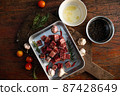 Sliced grilled thai steak served on white plate with grilled sliced lemon, tomatoes, garlic 87428649