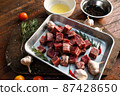 Sliced grilled thai steak served on white plate with grilled sliced lemon, tomatoes, garlic 87428650