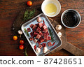 Sliced grilled thai steak served on white plate with grilled sliced lemon, tomatoes, garlic 87428651