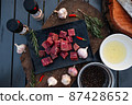 Sliced grilled thai steak served on white plate with grilled sliced lemon, tomatoes, garlic 87428652