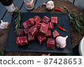 Sliced grilled thai steak served on white plate with grilled sliced lemon, tomatoes, garlic 87428653