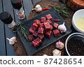Sliced grilled thai steak served on white plate with grilled sliced lemon, tomatoes, garlic 87428654