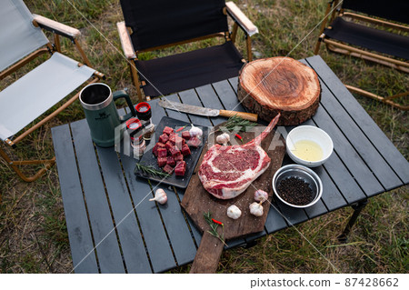 Sliced grilled thai steak served on white plate with grilled sliced lemon, tomatoes, garlic 87428662