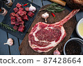 Sliced grilled thai steak served on white plate with grilled sliced lemon, tomatoes, garlic 87428664