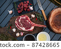 Sliced grilled thai steak served on white plate with grilled sliced lemon, tomatoes, garlic 87428665