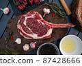 Sliced grilled thai steak served on white plate with grilled sliced lemon, tomatoes, garlic 87428666