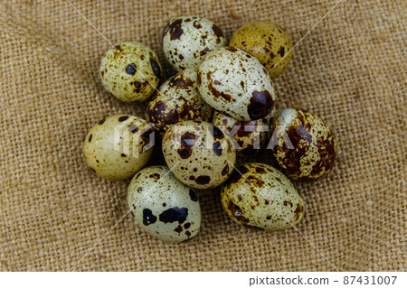Quail eggs on a sackcloth background. Top view 87431007