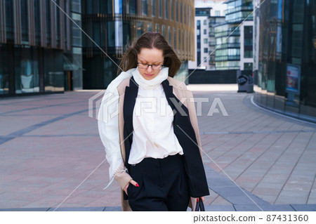 Female portrait of a business woman wearing glasses at the business center Female portrait of a business woman wearing glasses at the business center 87431360