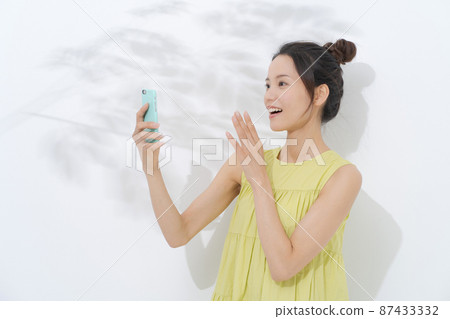 Woman with a smartphone white background 87433332