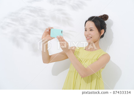 Woman with a smartphone white background Woman with a smartphone white background 87433334