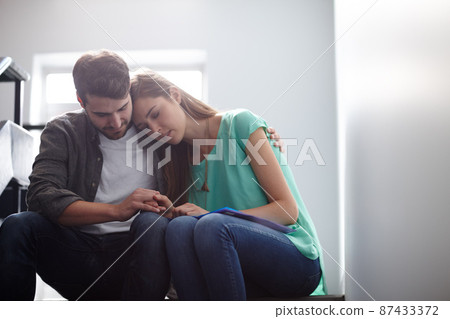 Its going to be all right.... Shot of a man comforting a distressed woman in a stairwell. Its going to be all right.... Shot of a man comforting a distressed woman in a stairwell. 87433372