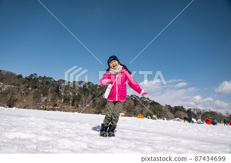 A girl jumping on the slopes A girl jumping on the slopes 87434699