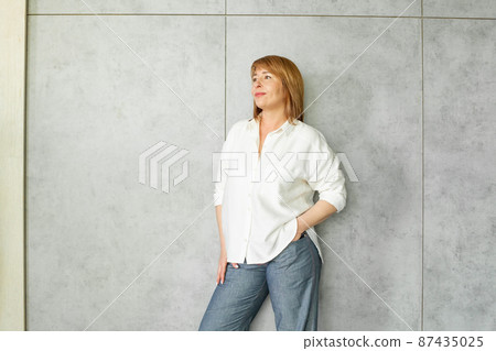 Portrait of smiling confident successful business woman looking up on grey background Portrait of smiling confident successful business woman looking up on grey background 87435025