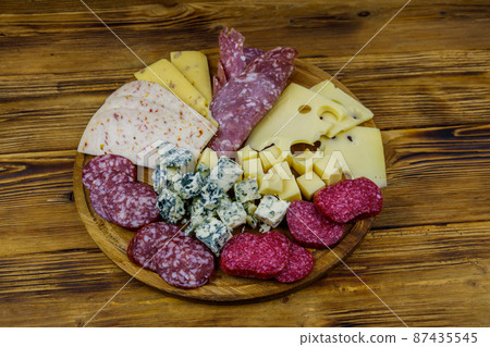 Antipasti platter with assortment of italian salami and cheese on wooden table 87435545