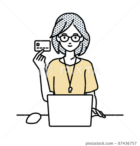 A teacher woman sitting at a desk and using a PC while holding a credit card 87436757