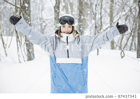 滑雪板女孩微笑著站在雪地滑雪場 87437341