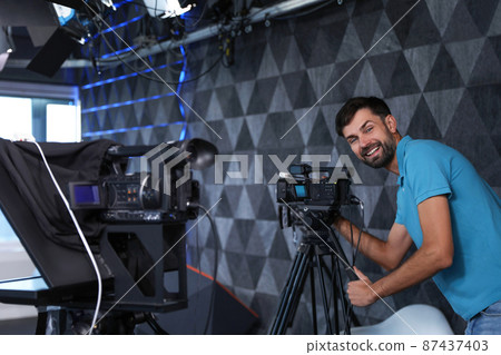 Professional video camera operator working in studio 87437403