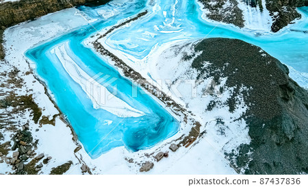 Turquoise colored frozen water in the quarry Turquoise colored frozen water in the quarry 87437836