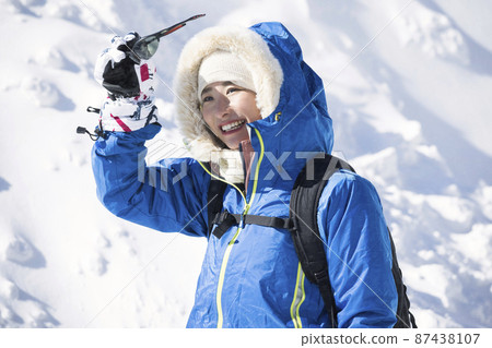Young woman climbing a winter mountain 87438107