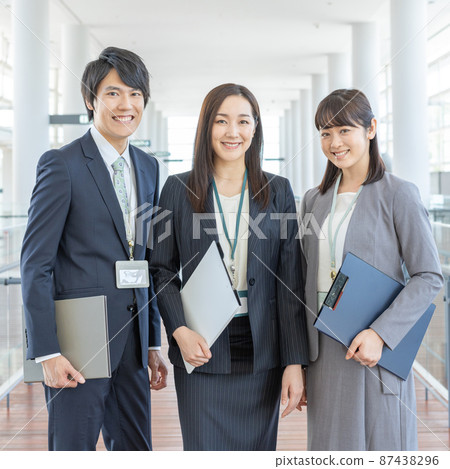 Portrait of three young business people standing in the aisle of a business office Square Portrait of three young business people standing in the aisle of a business office Square 87438296