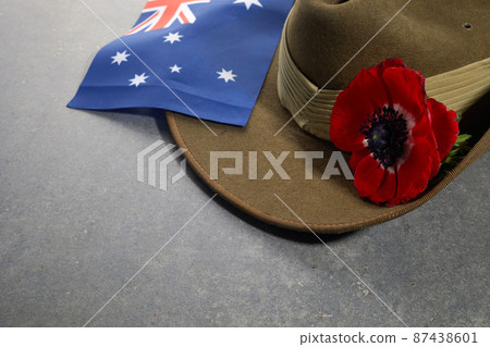 Anzac army slouch hat with Australian Flag and Poppy on stone background 87438601