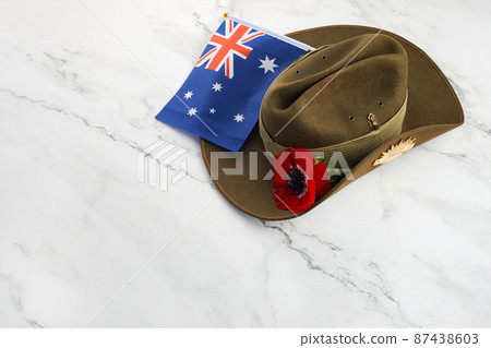 Anzac army slouch hat with Australian Flag and Poppy on stone background 87438603