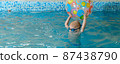 Toddler child playing with ball in indoor swimming pool with teacher. Diving, balancing and general physical activity for kids in water, early development. Boy kid instructed 87438790