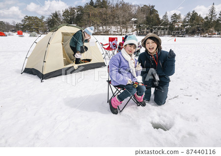 A girl fishing for smelt on the ice Winter camp 87440116