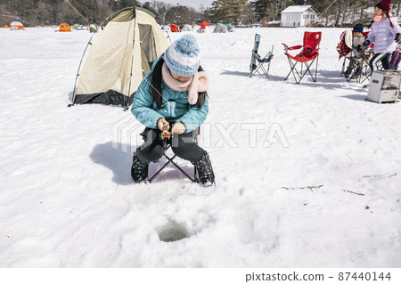 A girl fishing for smelt on the ice Winter camp 87440144