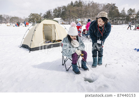 A girl fishing for smelt on the ice Winter camp 87440153