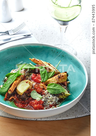 Meat with potatoes and vegetables served on a wooden table. 87443995