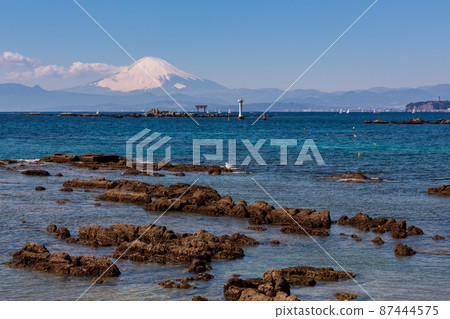 Torii and Mt. Fuji on the famous island in the morning from Hayama Mase Beach 87444575