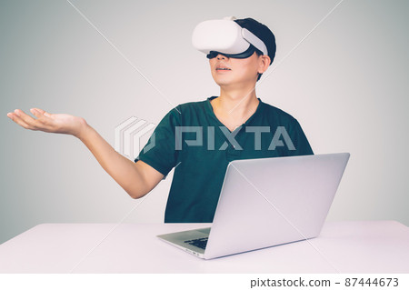 Portrait of young asian man wearing goggles virtual reality with excited isolated. Portrait of young asian man wearing goggles virtual reality with excited isolated. 87444673