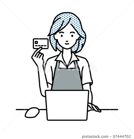 A woman in a cafe clerk sitting at a desk and using a PC while holding a credit card 87444702