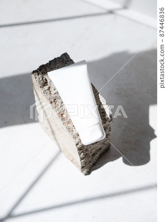 Clean white cream tube with trendy shadows and stone texture 87446836